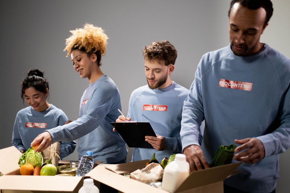 Volunteers sorting fresh produce and groceries into boxes