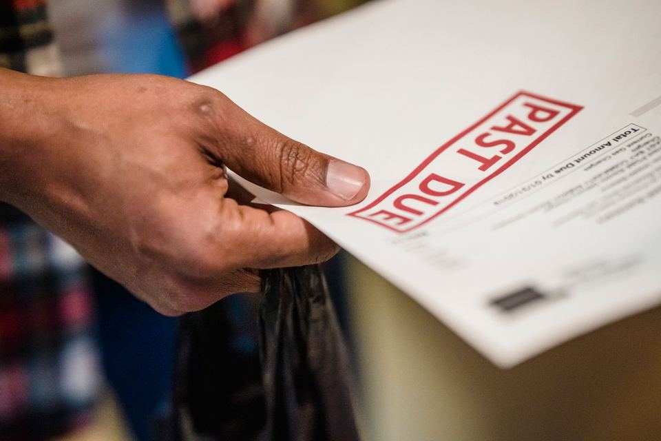 A hand holding a past due notice