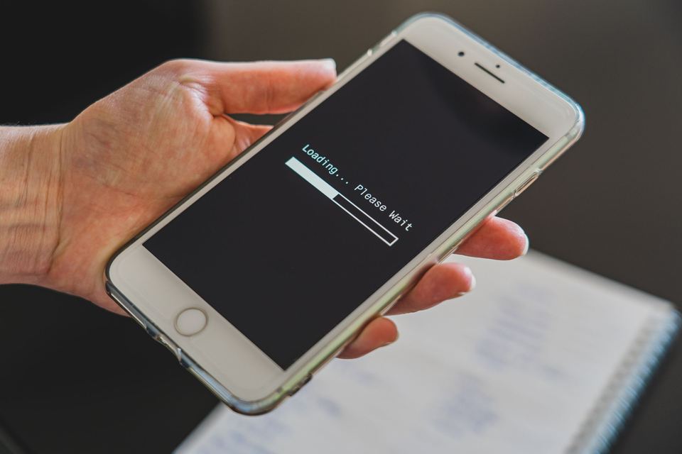 A hand holding a smartphone while it loads