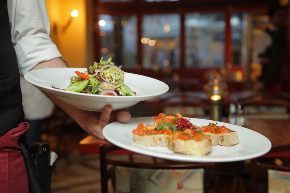 A server carrying plates of food in a restaurant