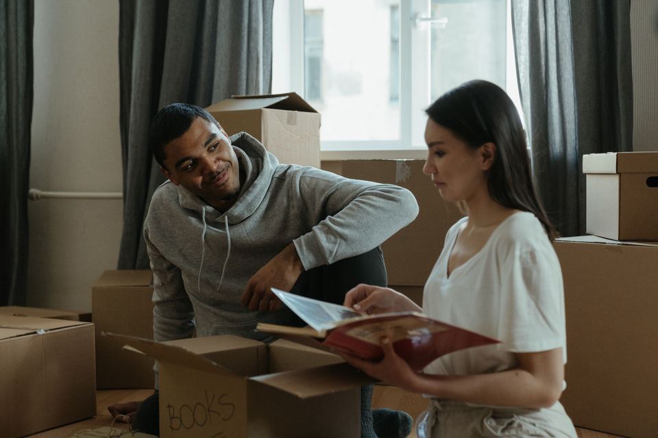 A couple unpacking cardboard boxes together in a new home
