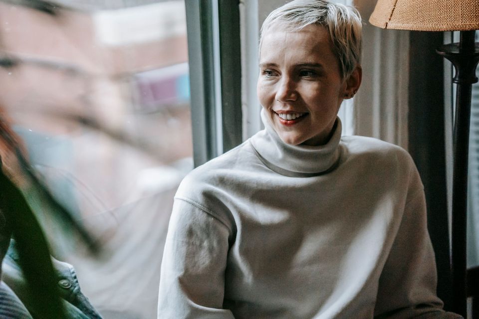A smiling woman with short gray hair in a sweater
