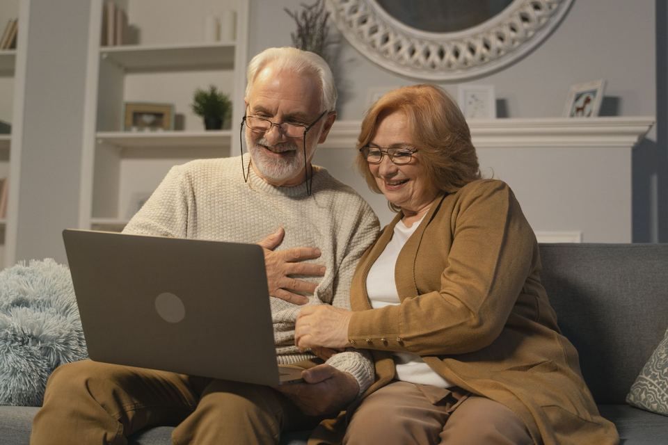 An older couple looking at a laptop together at home