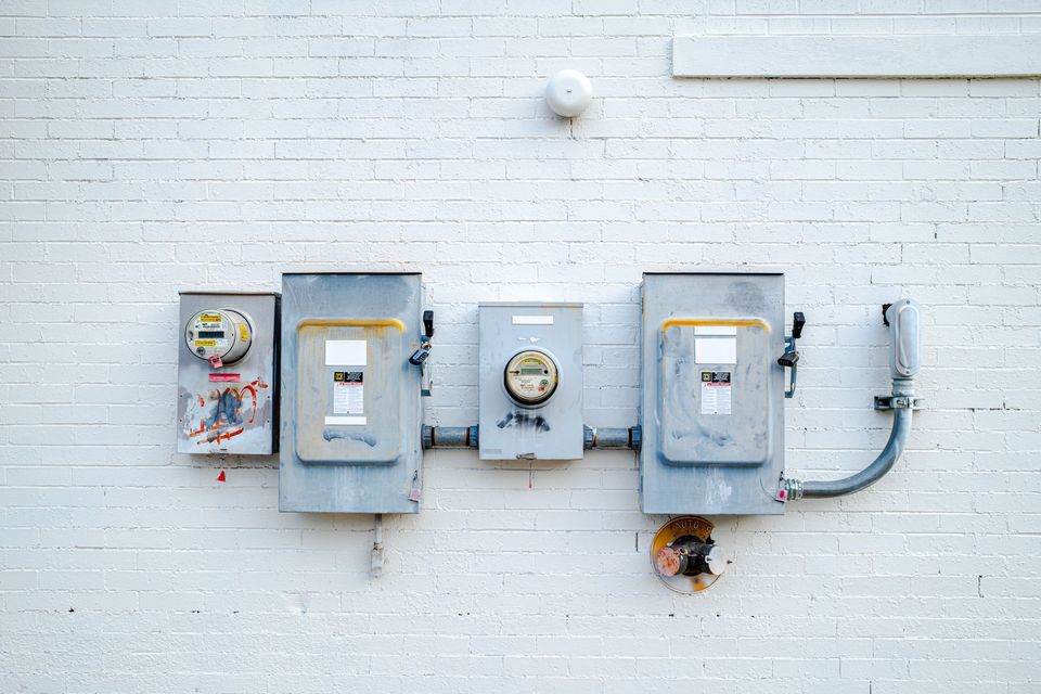 Electric meters mounted on a white brick wall